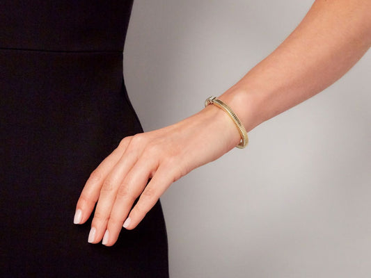 Hand wearing an 18K gold tubogas diamond bracelet