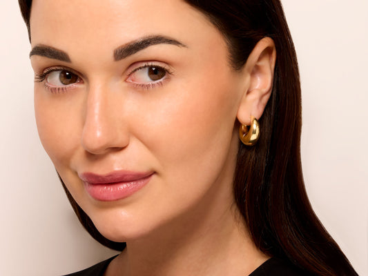 Woman wearing a polished gold crescent hoop earring