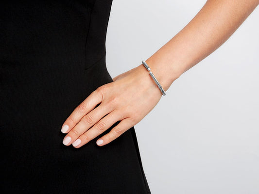 Hand wearing a slim white gold diamond bangle bracelet