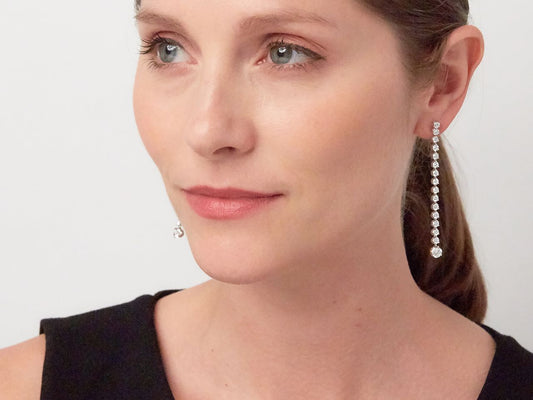 Close up of woman wearing a long diamond drop earring