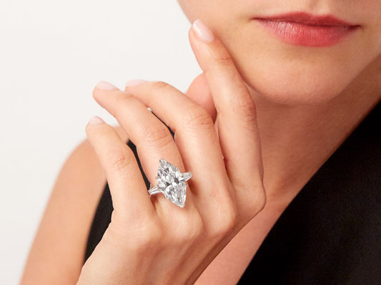 Marquise diamond ring with baguette shoulders on hand