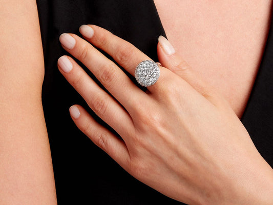Hand wearing a pavé diamond dome ring in white gold