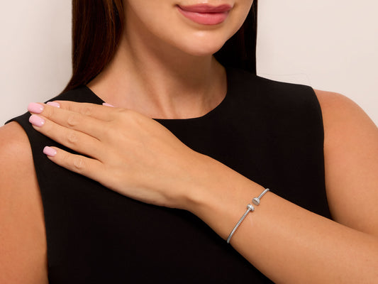 Woman wearing a slim white gold nail head bracelet