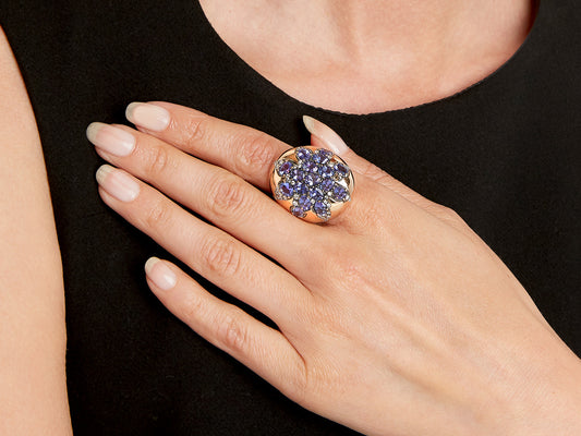 Hand wearing an oval tanzanite and diamond ring