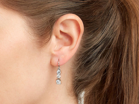 Close up of woman wearing a dangling diamond earring