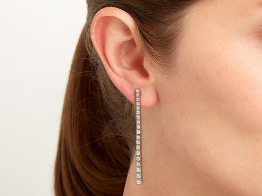 Diamond line earring in 18K white gold worn on ear