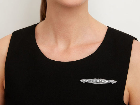 Platinum diamond bar brooch worn on a black dress