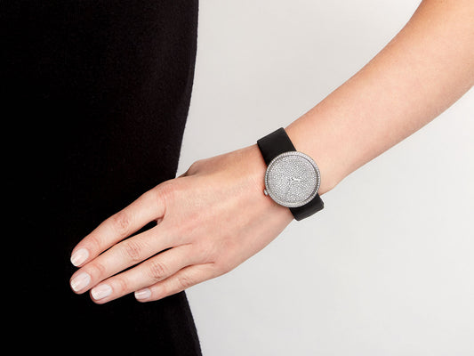 Diamond watch with black satin strap worn on wrist