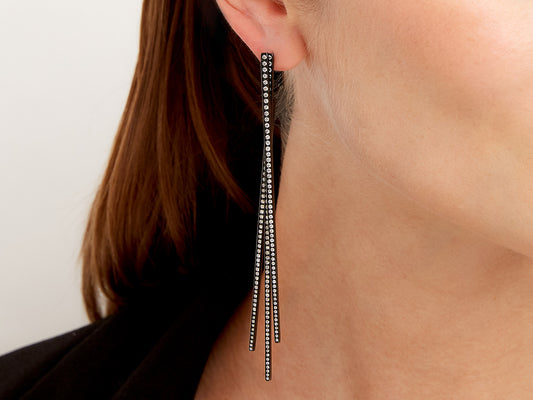 Blackened gold diamond drop earring worn on the ear