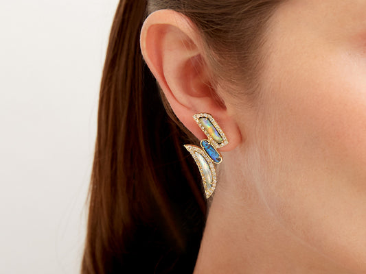 Opal and diamond earring in gold worn on ear