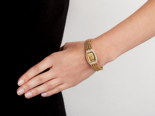Boucheron gold watch with diamond bezel worn on wrist