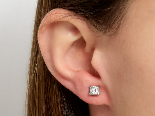 Princess cut diamond stud earring in platinum worn on ear