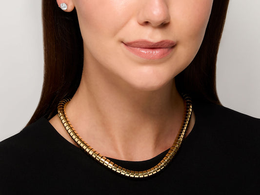 Woman wearing a polished 18K gold flexible tube necklace
