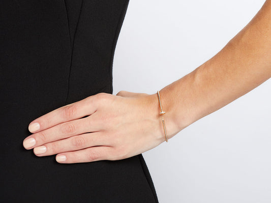 Thin 18K rose gold nail bracelet on a wrist