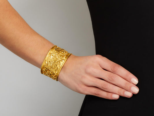 Wide textured 22K gold cuff with abstract figure motifs