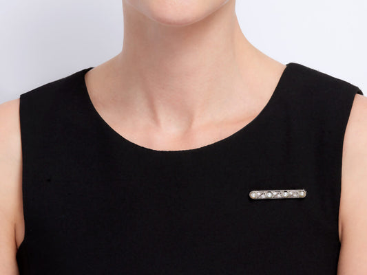 Pearl and diamond bar brooch on black dress