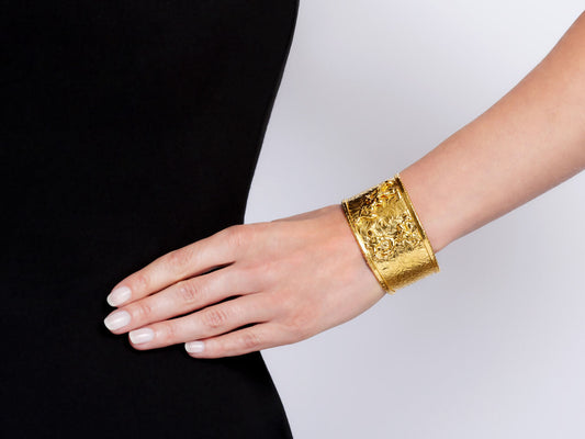 Wide textured 22K gold cuff bracelet worn on wrist