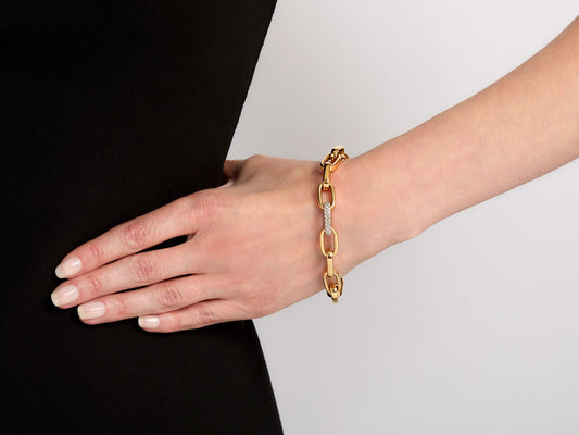 Hand wearing an 18K gold link bracelet with diamond