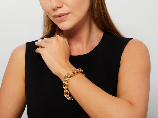 Woman wearing a polished 18K gold oval link bracelet