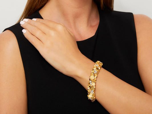 18K gold diamond bracelet with textured discs on wrist