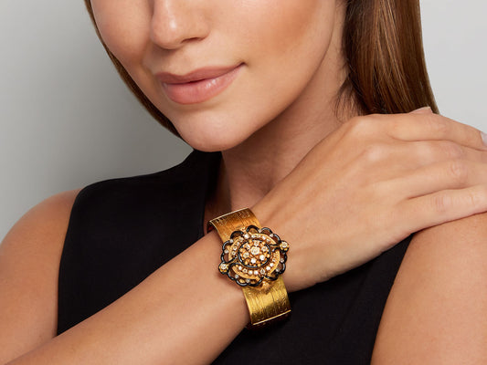 Woman wearing an ornate gold diamond enamel bracelet
