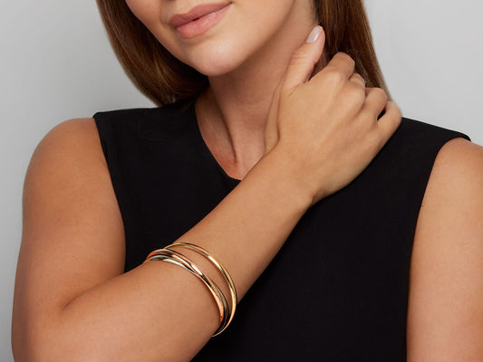 Woman wearing a tri color 18K gold Trinity bangle