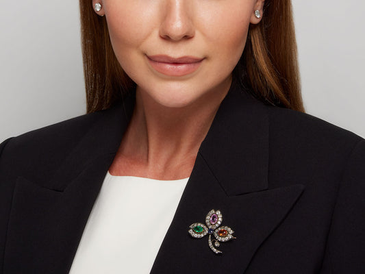 Multigemstone clover brooch pinned to a black blazer