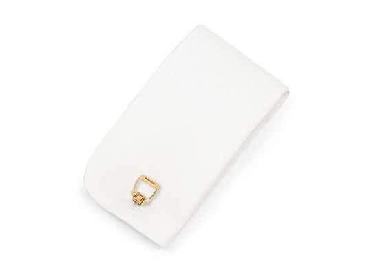 White presentation box holding a gold cufflink