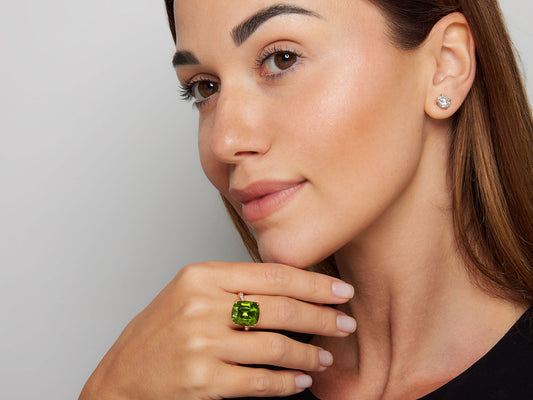 Model wearing a peridot and diamond rose gold ring