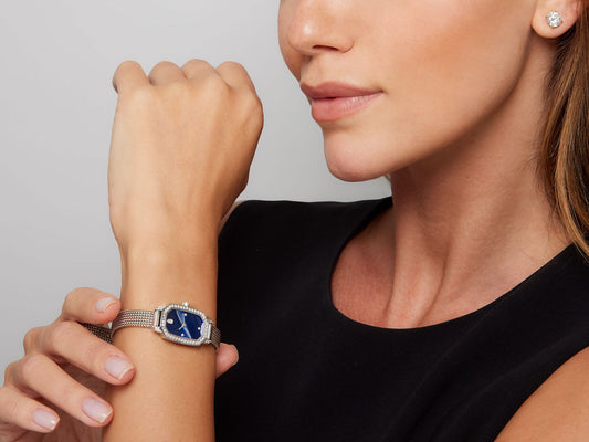 Woman wearing a diamond watch with a blue dial