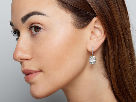 Woman wearing an 18K white gold diamond drop earring