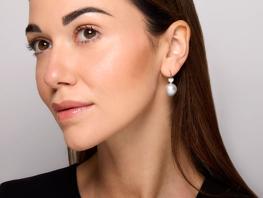 Model wearing a pearl and diamond drop earring