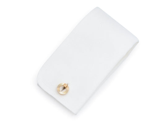 White cufflink box with a fluted gold circular clasp