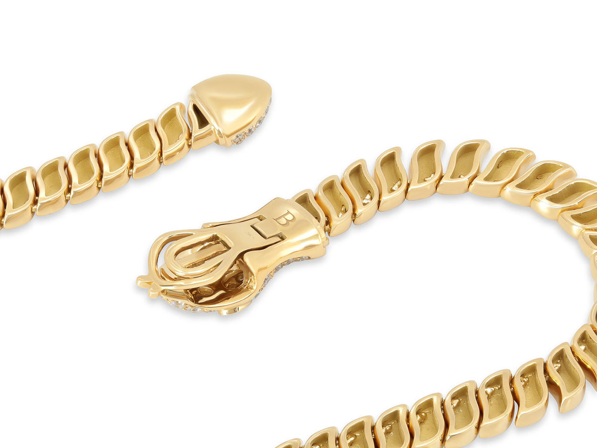 Close up of a polished gold snake necklace clasp