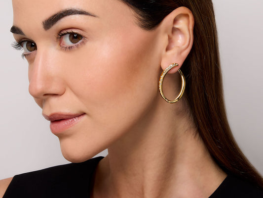 Woman wearing an 18K gold diamond loop earring