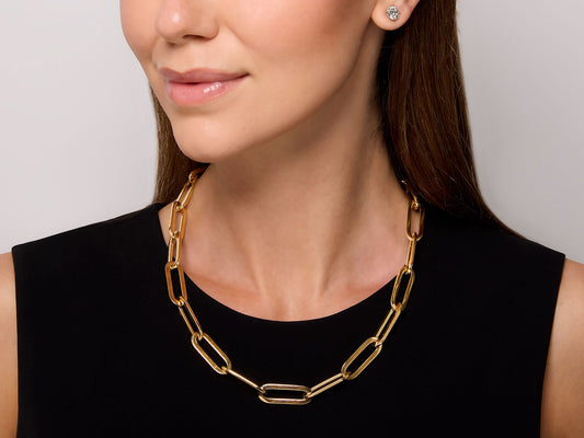 Gold elongated link necklace worn on a woman