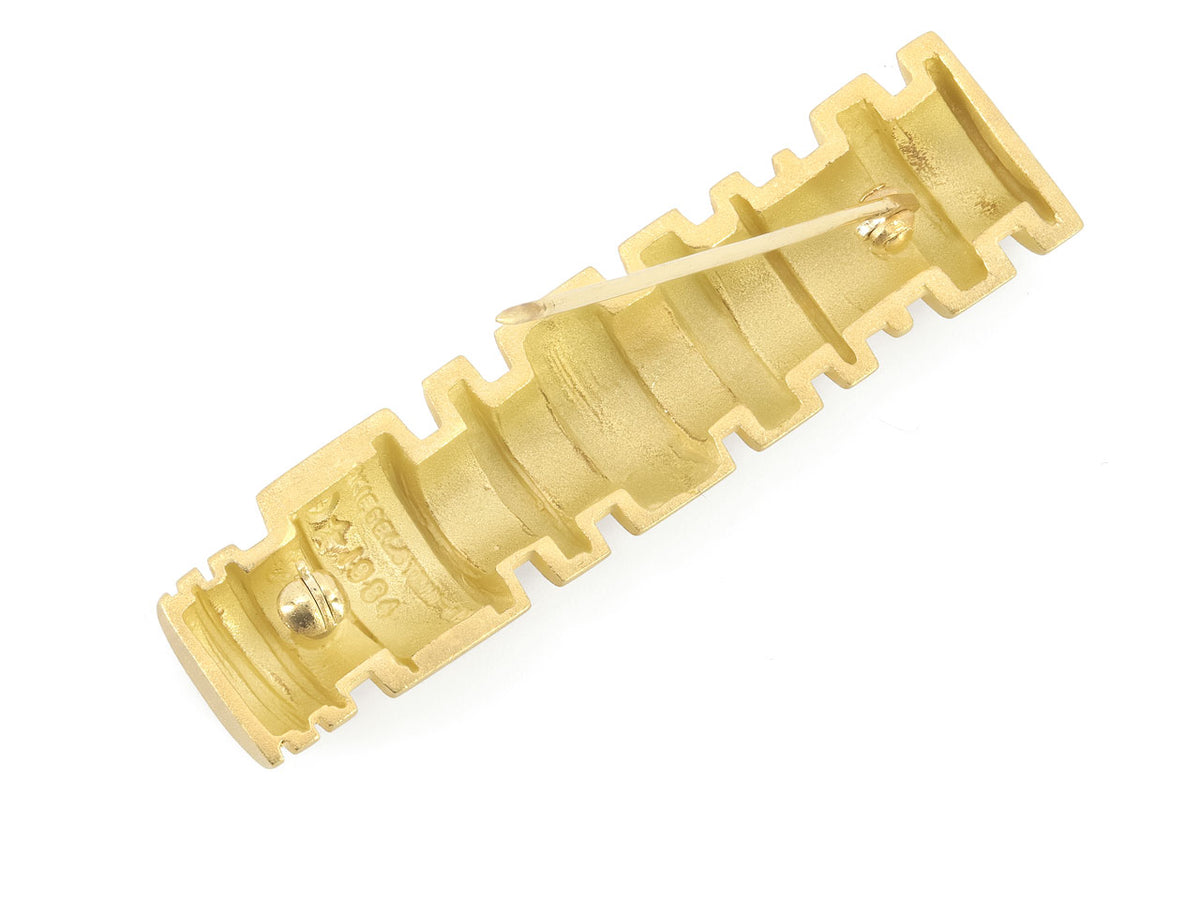 Back view of a grooved cylindrical 18K gold brooch