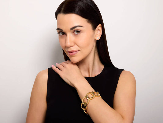 Model wearing a large link 18K yellow gold bracelet