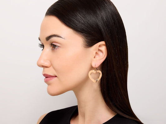 Woman wearing an 18K rose gold heart earring
