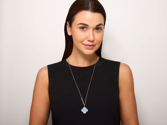 Van Cleef & Arpels 'Magic Alhambra' Chalcedony Necklace in 18K White Gold worn by a model, featuring a chalcedony clover pendant on a long chain from Beladora