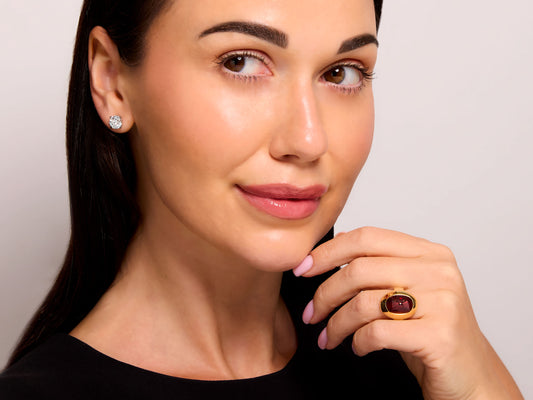 Pomellato Garnet Ring in 18K Gold worn by a model, featuring an oval sugarloaf cabochon garnet bezel set in high polish yellow gold