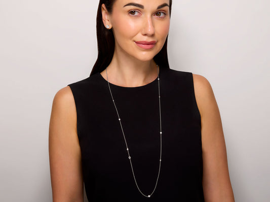 Tiffany & Co. Elsa Peretti 'Diamonds by the Yard Sprinkle' Necklace in Platinum worn by a model, featuring a fine chain and bezel set diamonds, Beladora