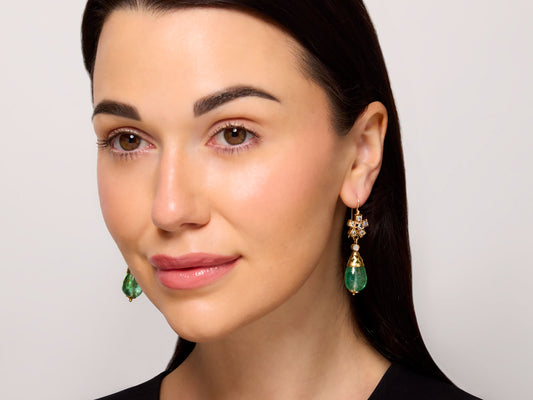 Antique Victorian Emerald and Diamond Earrings in 18K Gold worn by a model, featuring dangling green emeralds and diamond accents by Beladora