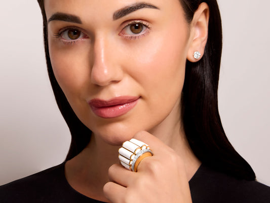 David Webb 'Scallop' White Enamel and Diamond Ring in 18K Gold worn by a model, featuring graduated diamonds and a tapering gold band.