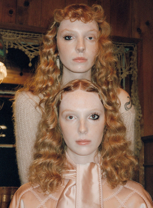 Portrait of two red haired women with curly hair indoors