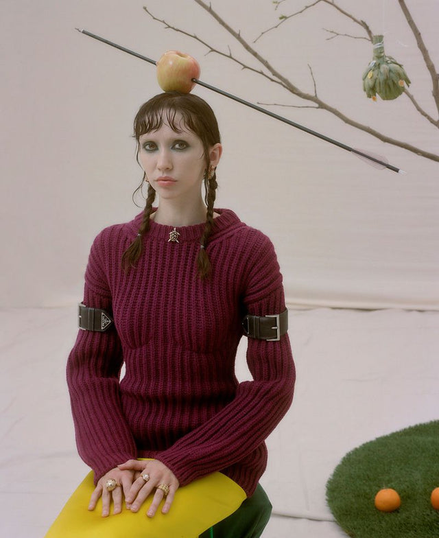 Woman in a burgundy sweater with an apple on her head