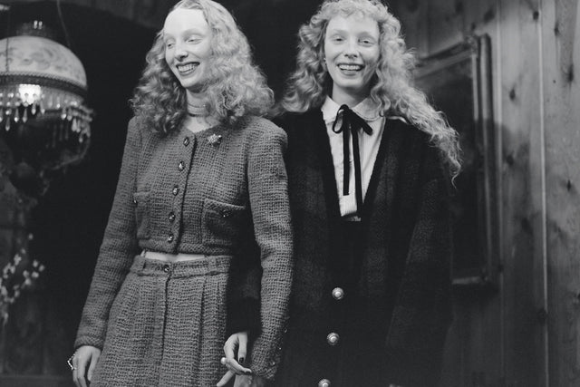 Two smiling women in vintage clothing indoors