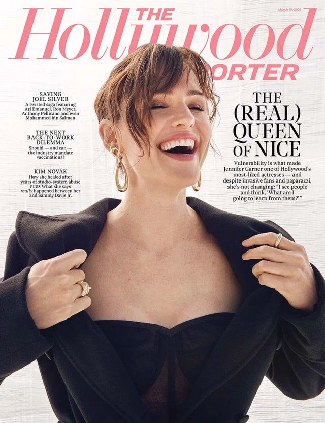 Smiling woman in a black outfit on a magazine cover