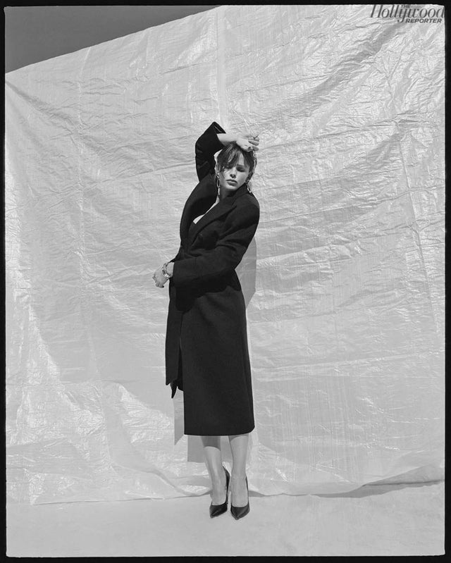 Black and white portrait of a woman in a long dark coat