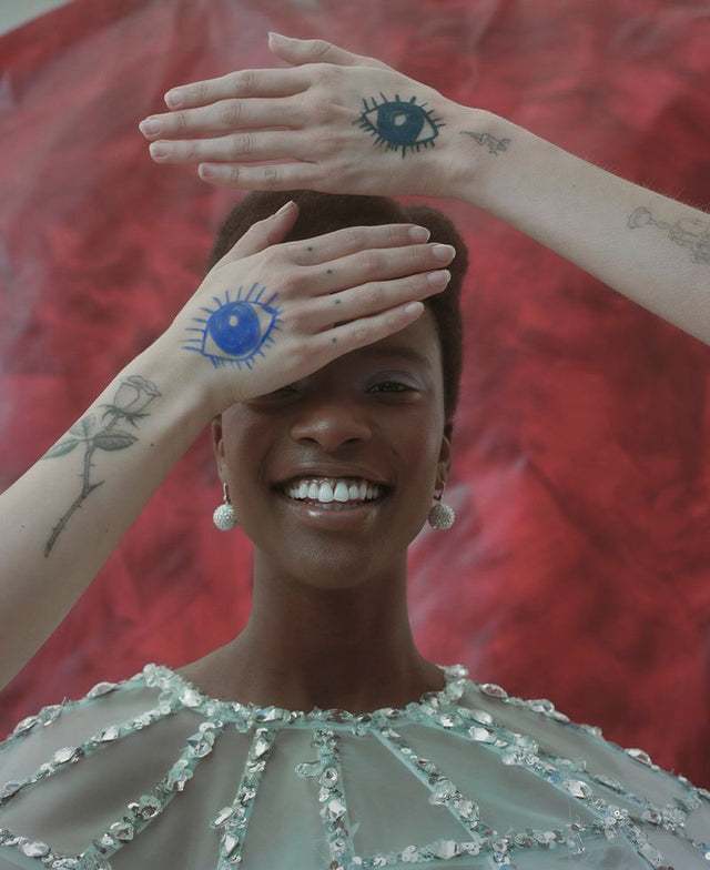 Smiling woman with sun tattoos over her eyes